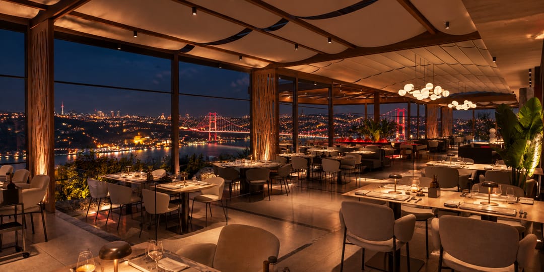 7 Hills salonu gece; cam cepheden ışıklı Boğaz Köprüsü ve İstanbul görünüyor
